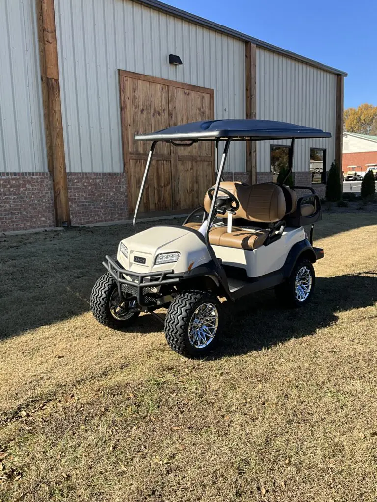 A golf cart with a canopy is parked in the grass.