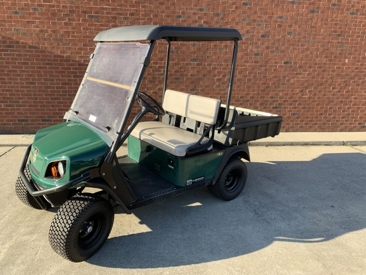 A green golf cart parked in the driveway.
