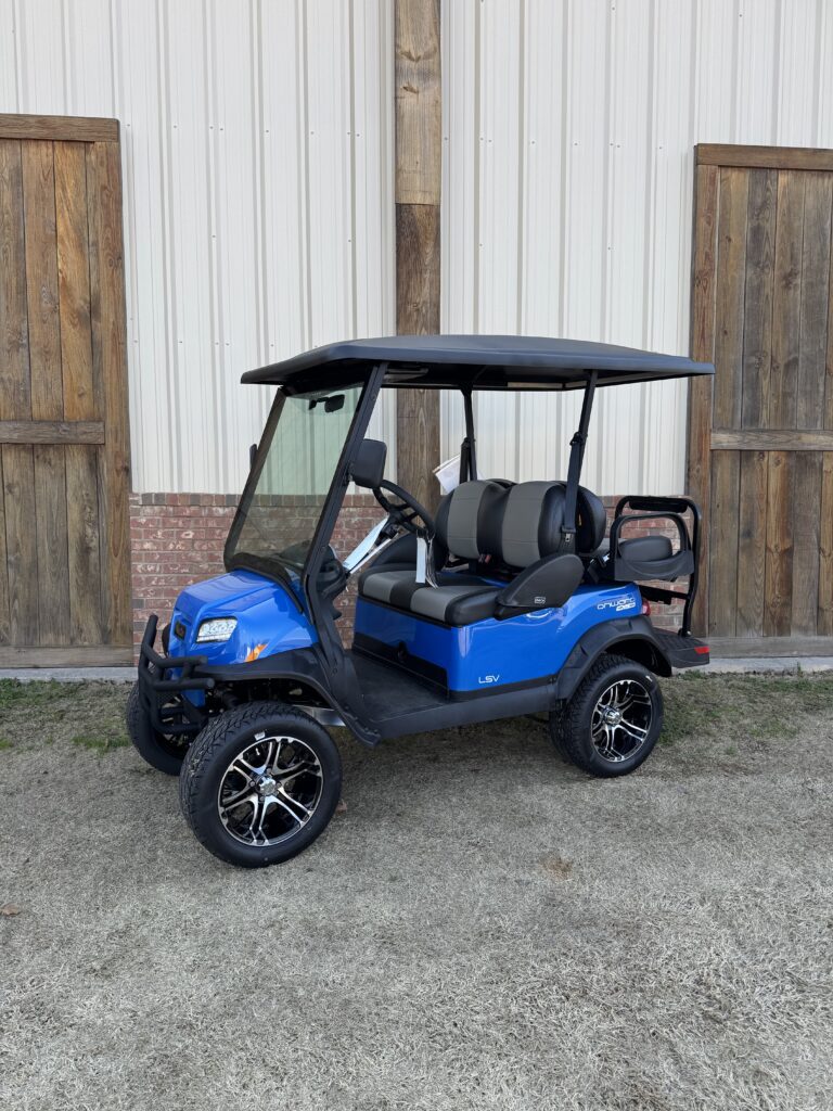 Blue golf cart with black roof and lifted wheels parked outdoors.