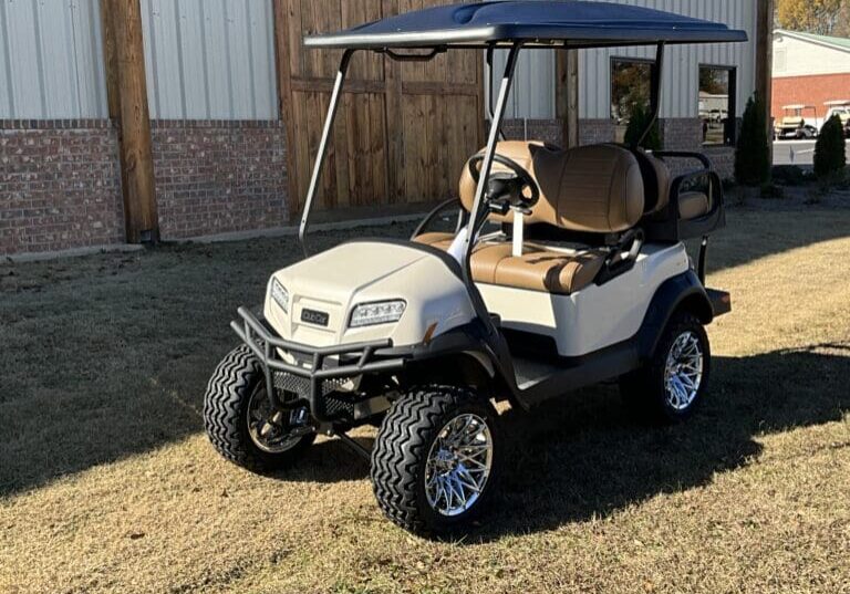 A golf cart with a canopy is parked in the grass.