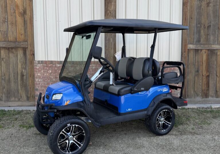 Blue golf cart with black roof and lifted wheels parked outdoors.