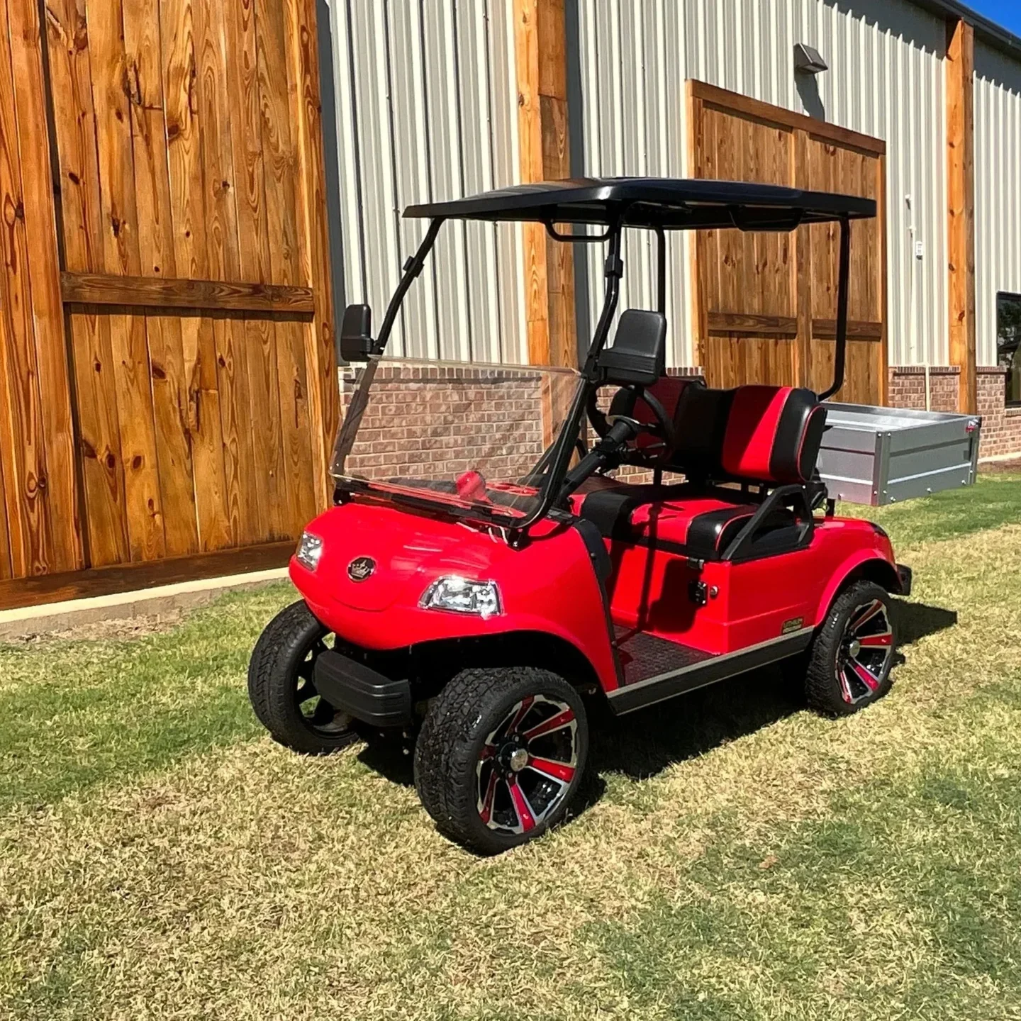 A red golf cart parked in the grass.